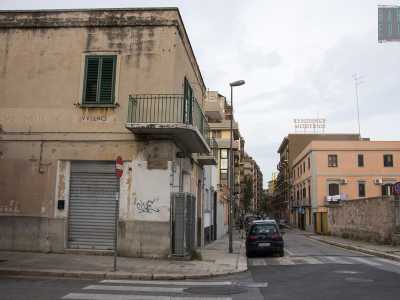 ...e a destra un caseggiato su cui � ben visibile una scritta risalente al Ventennio fascista. La palazzina fa angolo con via Carafa...